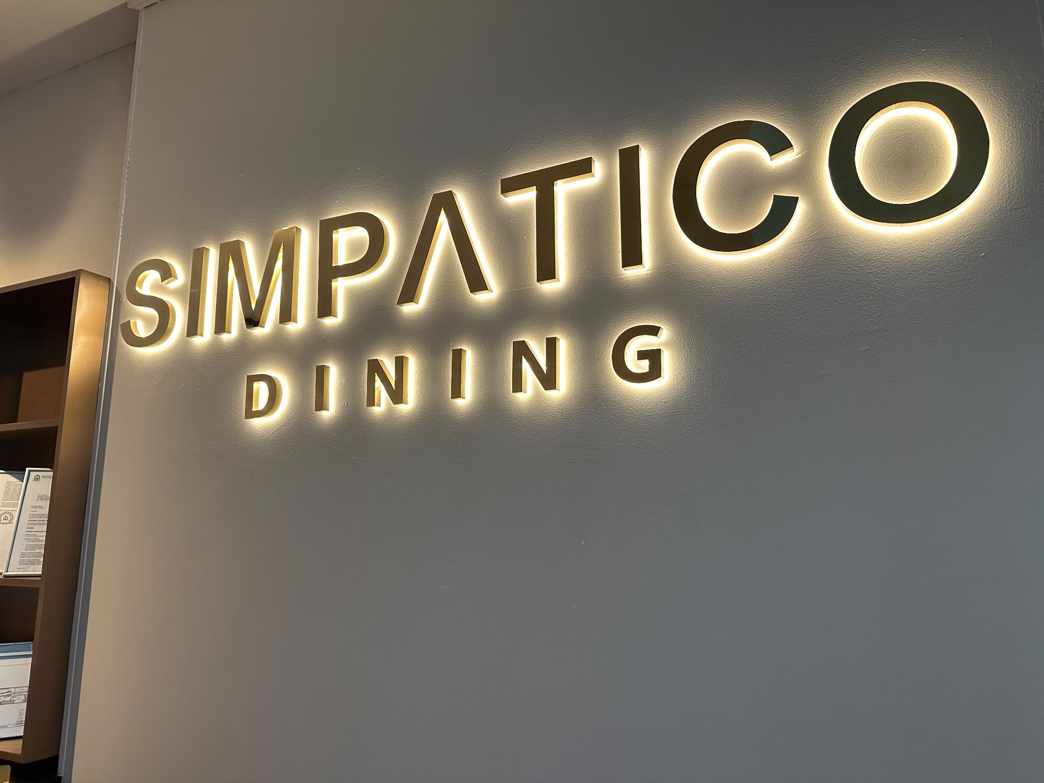 The illuminated official Simpatico Dining sign